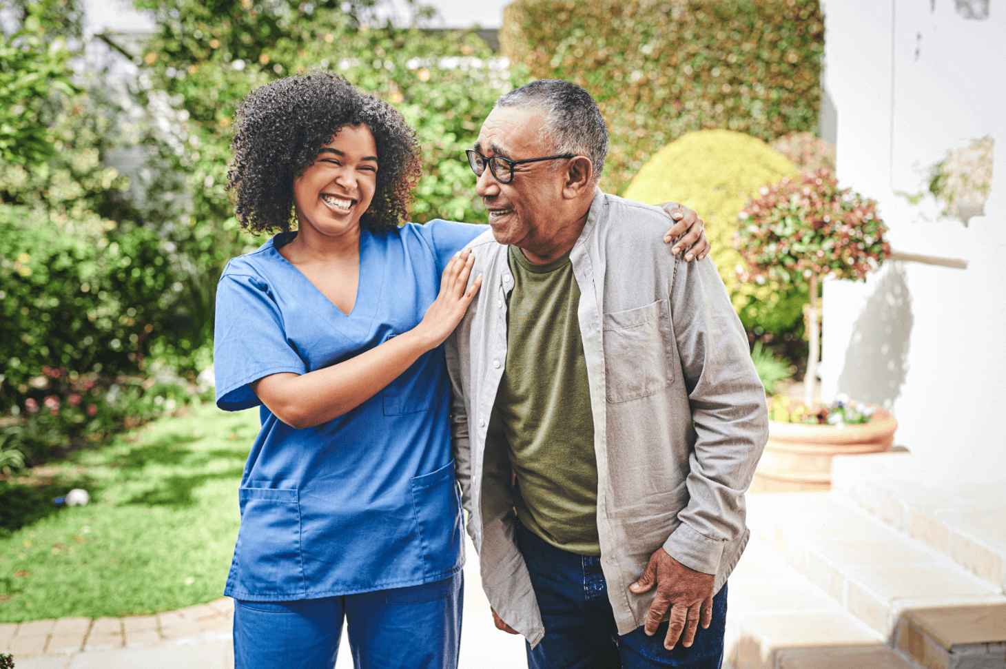 Nurse and patient stand together outside.