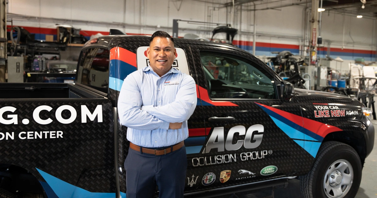 Man stands in a car repair shop that received an SBA 504 loan from CDC Small Business Finance.