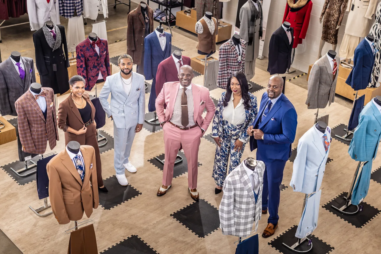 The Tayion Collection staff stands together featuring many of their designs. Impact Investment’s non-dilutive funding helps businesses with growth capital through alternative funding options.