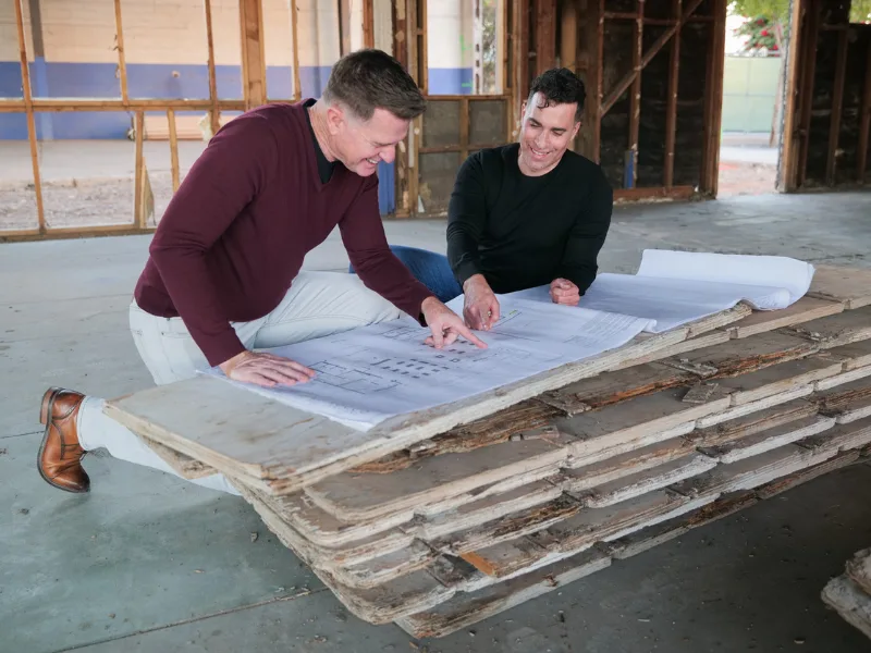 SBA SOP Changes Feature image of two borrower reviewing blueprints in their newly acquired location.