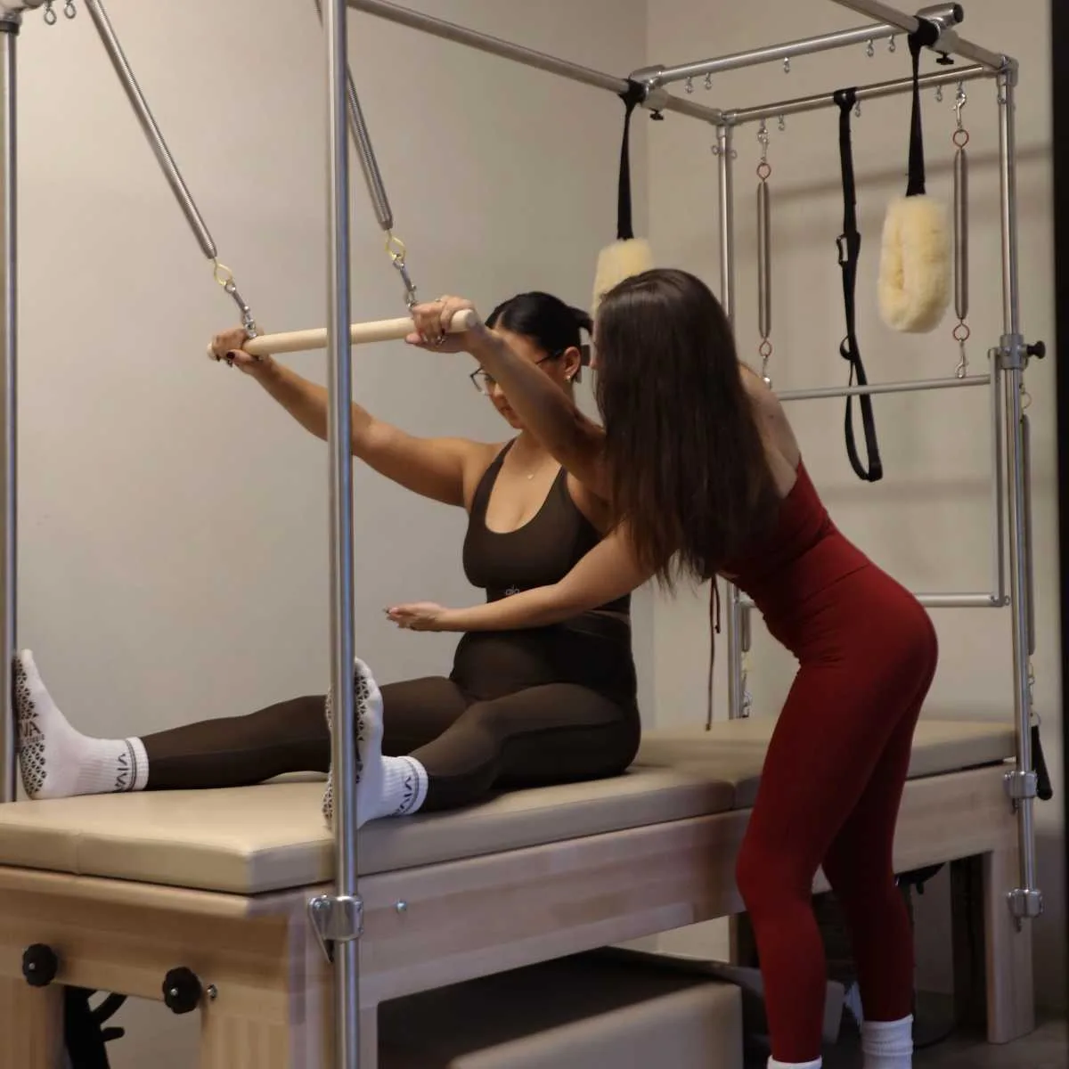 Woman exercising with an instructor using Viva Starter Package - 1 Private Session and 2 Group Reformer Classes for only