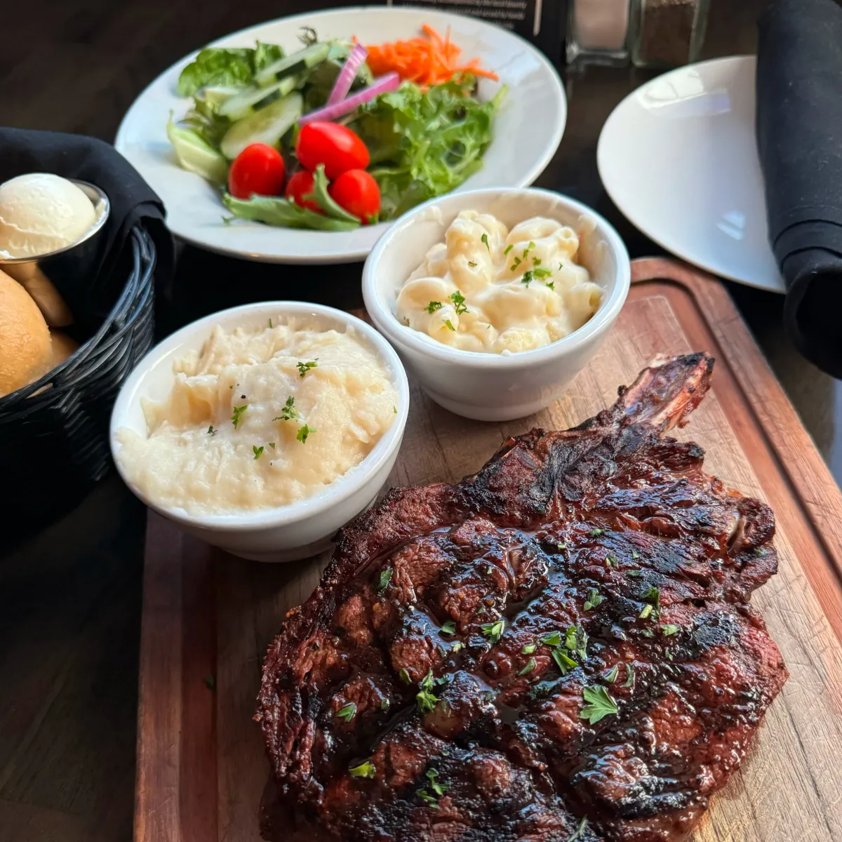 CheyAnne’s Steakhouse and Lounge dining room with premium 24oz Cowboy Ribeye steak and sides, featured in the Momentus Capital small business holiday gift guide as a dining and experience gift.