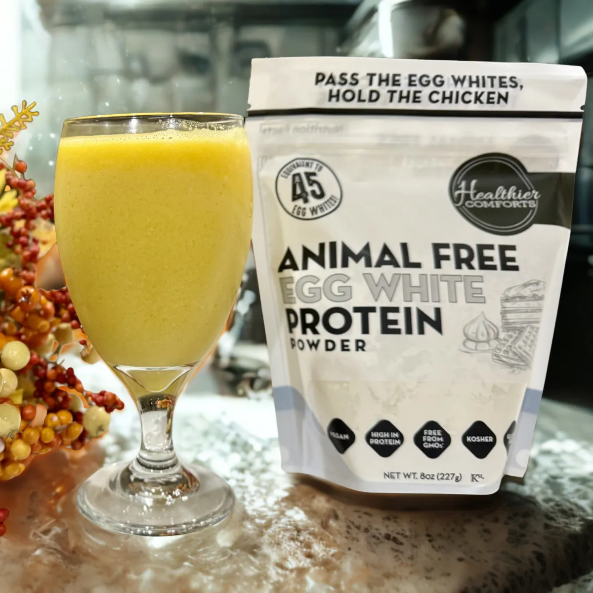 Healthier Comforts animal free egg white protein powder displayed in a bright kitchen scene, highlighted in the Momentus Capital small business gift guide as a better for you holiday gift.