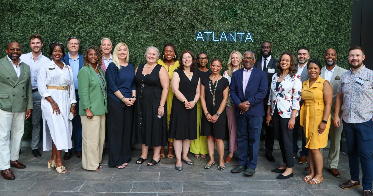 Group photo of Momentus Capital staff in front of a plant wall